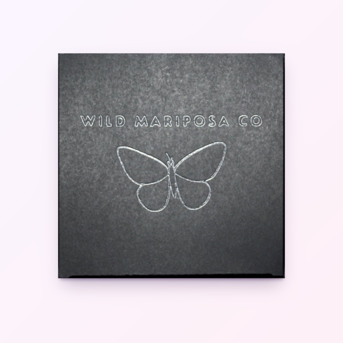 A Wild Mariposa gift box with the butterfly logo embossed on the lid